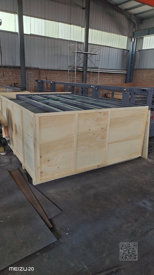 Scissor lift secured in wooden crate being loaded onto truck for export shipment at Beacon Industries