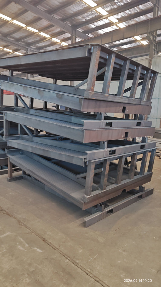 BEACON worker welding the steel frame of a fixed dock leveler in the manufacturing workshop