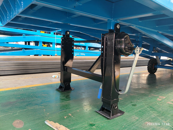 Two black auxiliary support legs with square footplates and a hand crank beneath a blue mobile dock ramp frame