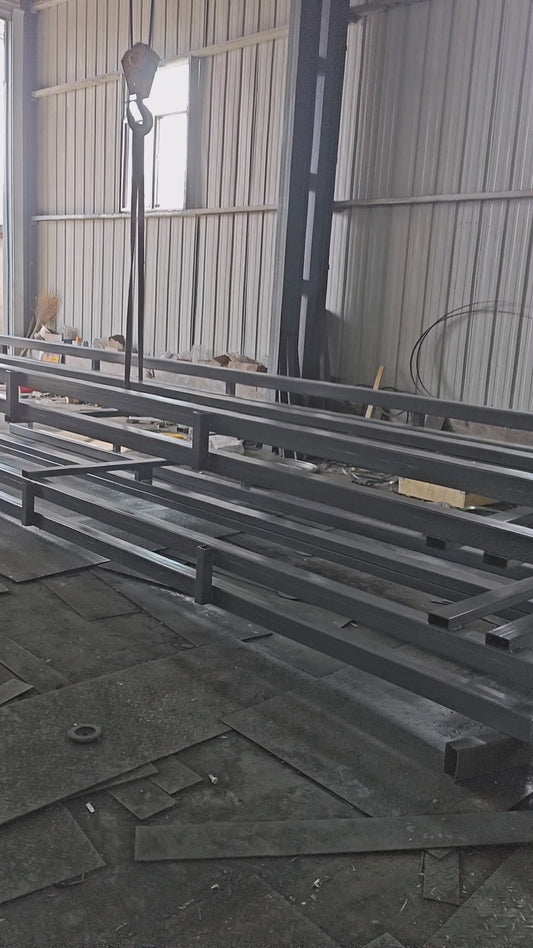 Welded guide rails for hydraulic lift stacked by overhead crane before shipment