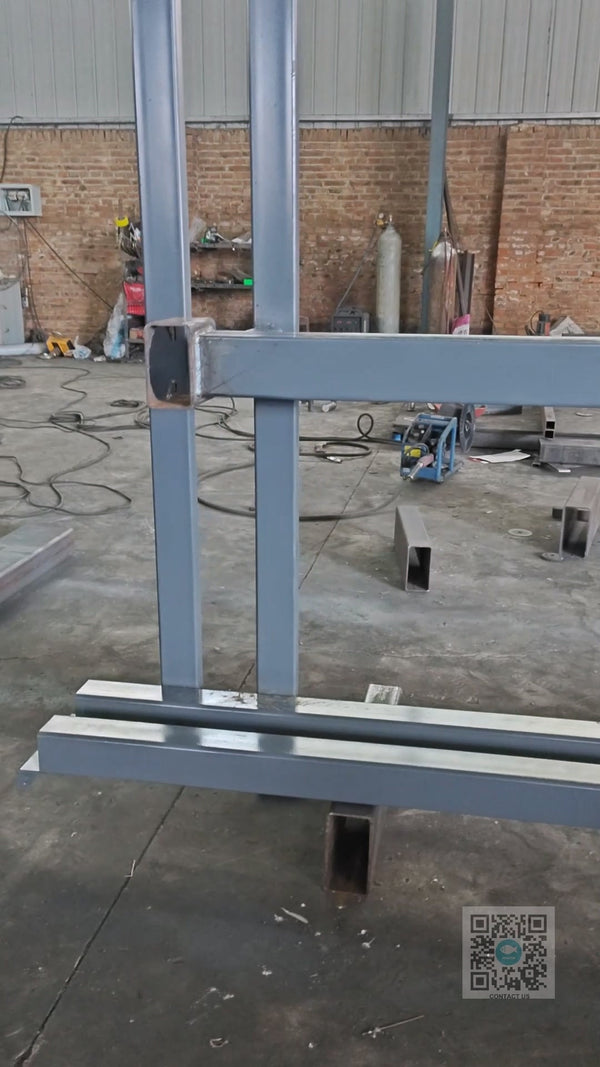 Worker welding hydraulic cylinder mounting base onto guide rail lift structure at Beacon Industries